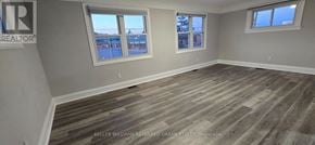 Oshawa (Vanier) apartment for rent - A room with wooden flooring and two windows.