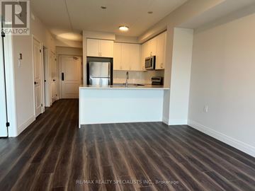 Milton (Co Coates) condo for rent - A kitchen with white cabinets and a wooden floor.