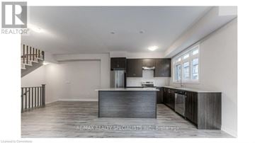 Brantford townhouse for rent - A modern kitchen with dark wood cabinets and a central island.