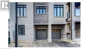 Brantford townhouse for rent - A brick building with a sign that says RE/MAX REALTY SPECIALISTS INC. Brokerage.