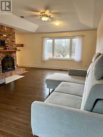 Mono apartment for rent - A living room with a grey couch and a fireplace.