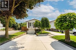 Hamilton apartment for rent - A house with a white front door is surrounded by greenery and a clear sky.