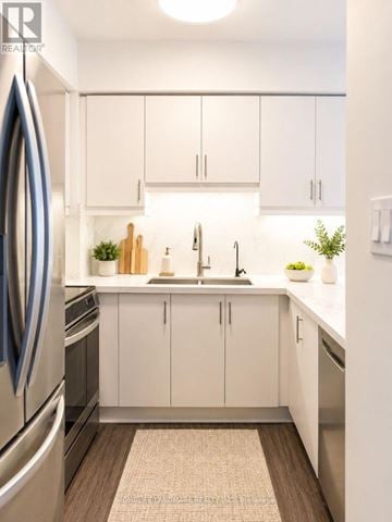 Vaughan (Brownridge) townhouse for rent - A modern kitchen with white cabinets and a wooden floor.