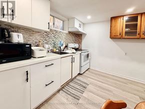 Niagara Falls (Dorchester) apartment for rent - A kitchen with white cabinets and a black stove top oven.