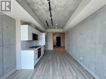 Toronto (Waterfront Communities) condo for rent - A modern kitchen with white cabinets and a wooden floor.