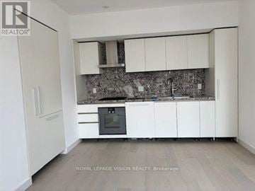 Toronto (Annex) condo for rent - A kitchen with white cabinets and a black oven.