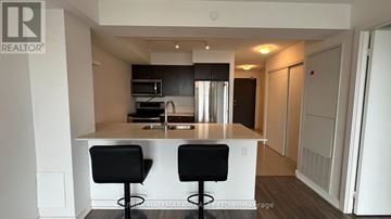 Toronto (East End-Danforth) condo for rent - A modern kitchen with a bar stool and a counter.