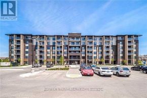 Guelph (Pineridge/Westminster Woods) condo for rent - A multi-story apartment building with cars parked in front.