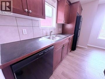 Calgary apartment for rent - A kitchen with a sink, dishwasher and refrigerator.