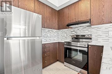 Thorold (Rolling Meadows) townhouse for rent - A modern kitchen with wooden cabinets and a stainless steel refrigerator.