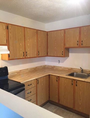 Gatineau (Gatineau) apartment for rent - A kitchen with wooden cabinets and a black stove top.
