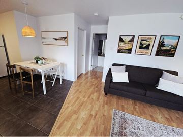 Gatineau (Hull) condo for rent - A living room with a couch, a dining table with chairs, and pictures on the wall.