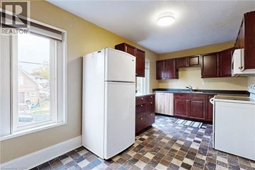 Oshawa apartment for rent - A kitchen with a white refrigerator and brown cabinets.