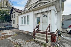 Oshawa apartment for rent - A white house with a brown door and a small porch.