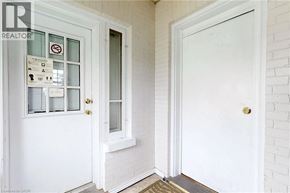 Oshawa apartment for rent - A white door with a glass window and a sign on the left side.
