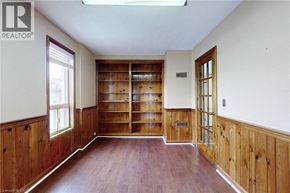 Oshawa apartment for rent - A room with wooden floors and a large bookcase.