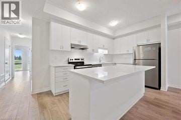 Kitchener townhouse for rent - A modern kitchen with white cabinets and a large island.