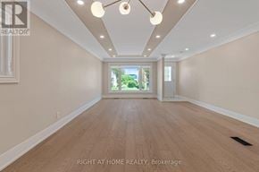 Toronto (Long Branch) apartment for rent - A spacious room with wooden flooring and a large window.