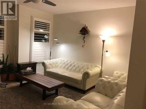 Oakville (Go Glenorchy) townhouse for rent - A white tufted couch sits in a living room with a wooden coffee table in front of it.