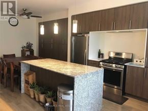 Oakville (Go Glenorchy) townhouse for rent - A kitchen with a granite countertop and stainless steel appliances.