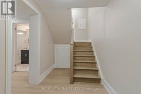 Toronto (Long Branch) apartment for rent - A staircase in a house with a white wall and a light switch.