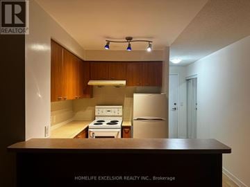 Toronto (Woburn) condo for rent - A kitchen with a stove and refrigerator in a small space.