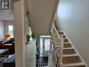 Burlington (Orchard) townhouse for rent - A hallway with a staircase and a door leading to a landing.