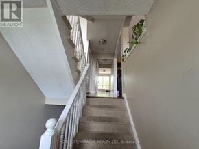 Burlington (Orchard) townhouse for rent - A staircase with a carpeted runner and white balusters leads to a bright room.