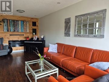 Burlington (Orchard) townhouse for rent - A living room with a red couch and a glass coffee table.