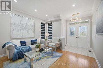 Brampton (Sandringham-Wellington) apartment for rent - A living room with a glass coffee table and a large painting on the wall.