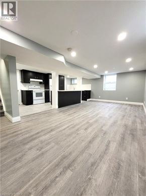 Cambridge apartment for rent - A spacious room with wood flooring and a kitchen area in the background.