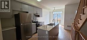 Oshawa (Donevan) townhouse for rent - A kitchen with a refrigerator, stove, and sink.