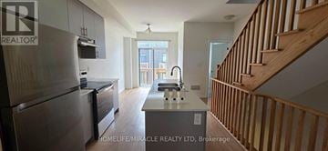 Oshawa (Donevan) townhouse for rent - A kitchen with a refrigerator, sink and stairs.