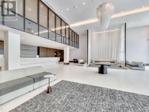 Markham (Commerce Valley) condo for rent - A spacious living room with a grey rug and a large chandelier.