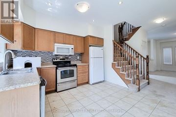 Grimsby (Grimsby West) townhouse for rent - A kitchen with wooden cabinets and a staircase.