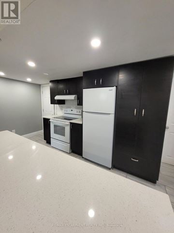 Cambridge apartment for rent - A white refrigerator sits in a kitchen with black cabinets.