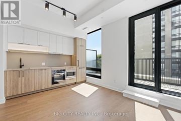 Toronto (Forest Hill South) condo for rent - A modern kitchen with wooden cabinets and a large window.