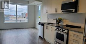 Hamilton (Beasley) condo for rent - A kitchen with white cabinets and a black stove top oven.