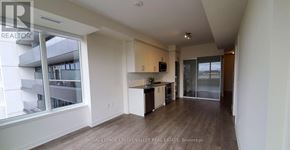 Hamilton (Beasley) condo for rent - A spacious room with wooden flooring and a large window overlooking a balcony with multiple balconies.