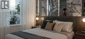 Burnaby apartment for rent - A bedroom with a large bed and a mirror on the wall.