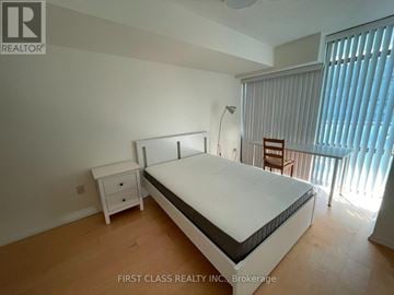 Toronto (Bay Street Corridor) condo for rent - A bedroom with a bed, nightstand, and chair.