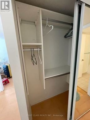 Toronto (Bay Street Corridor) condo for rent - A white closet with clothes hangers and a mirror.