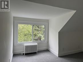 Toronto (North Riverdale) triplex for rent - A room with a window and a radiator.