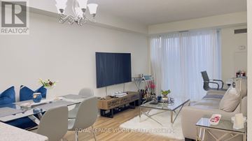 Toronto (Bendale) condo for rent - A living room with a glass table and a television on the wall.