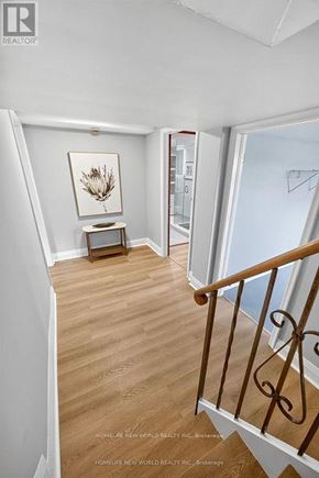 Toronto (Bathurst Manor) apartment for rent - A hallway with a wooden floor and a staircase with a metal railing.