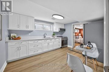 Toronto (Bathurst Manor) apartment for rent - A modern kitchen with white cabinets and a glass table.