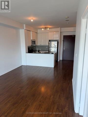 Toronto (Wexford-Maryvale) condo for rent - A spacious kitchen with white cabinets and a dark wood floor.