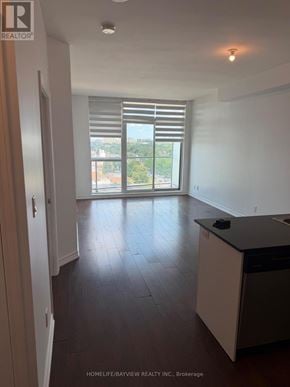 Toronto (Wexford-Maryvale) condo for rent - A spacious kitchen with dark wood floors and white walls.