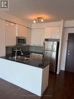 Toronto (Wexford-Maryvale) condo for rent - A modern kitchen with stainless steel appliances and white cabinets.