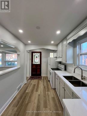 Toronto (Keelesdale-Eglinton West) apartment for rent - A kitchen with white cabinets and a wooden floor.